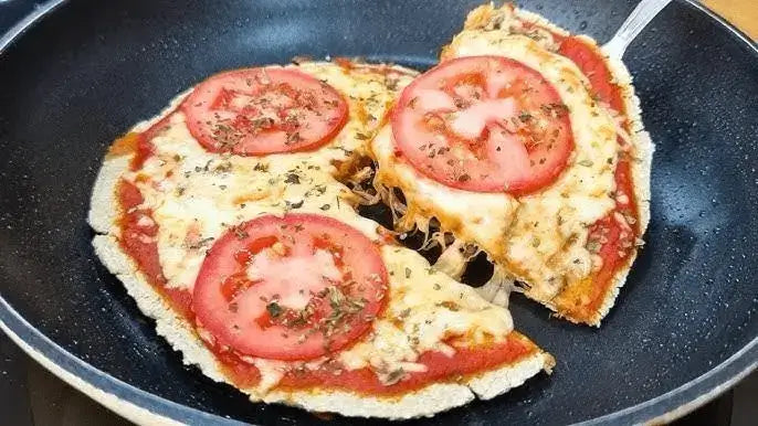Mini pizza de sartén con tomate y queso derretido.