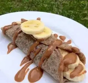 Crepe enrollado con bananas y salsa de mantequilla de maní.