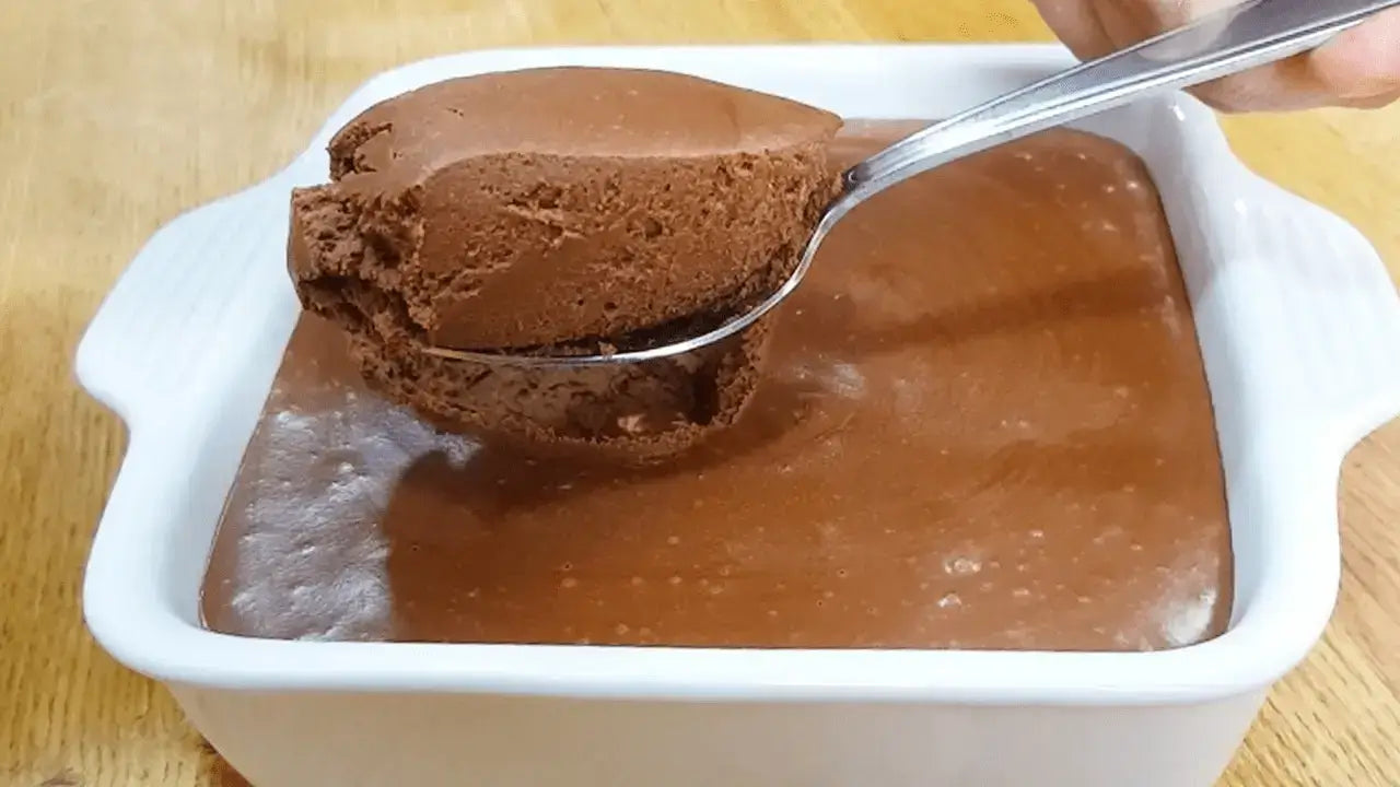 Mousse aireado de chocolate servido con cuchara en fuente blanca.